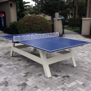 A table tennis table in the middle of an outdoor court.