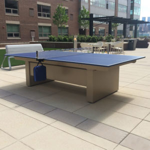 A table tennis table in the middle of an outdoor area.