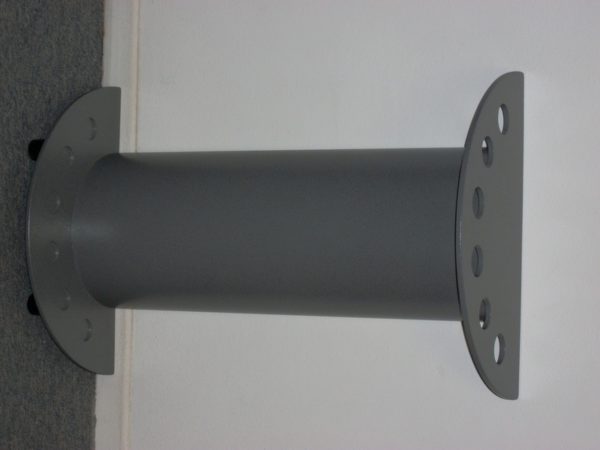 A metal pole with holes in it sitting on the wall.