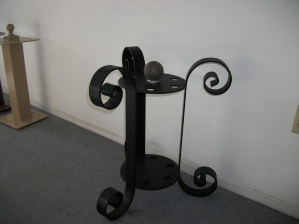 A black metal table with two wheels on it.