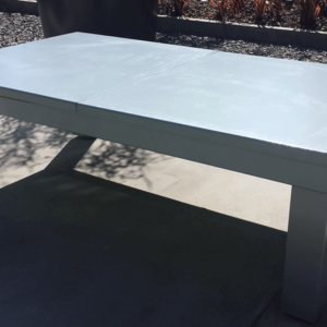 A white table sitting on top of cement.