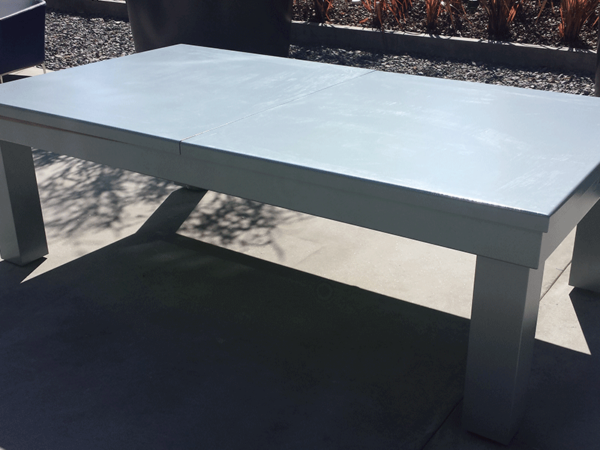 A white table sitting on top of cement.