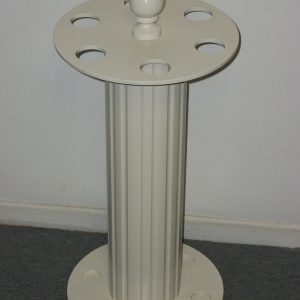 A white pillar with a cup on top of it.